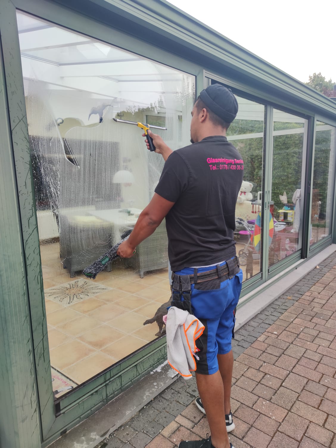Rodrigo Santos bei der Glasreinigung an einem Wintergarten in der Region Aachen